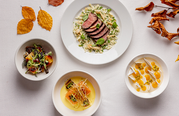 Flat lay of food plates with orange leaves on tablejpg