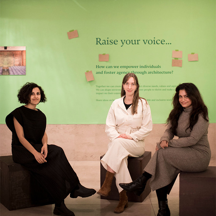 Msoma architects sitting infront of Raise the Roof exhibitionjpg