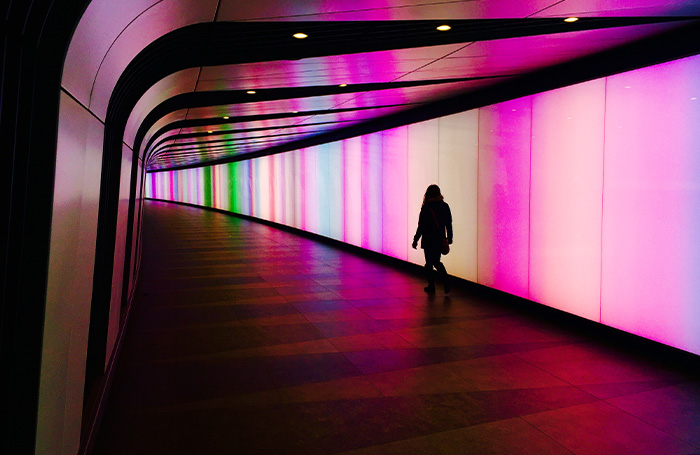 Person in Kings Cross colourful light tunneljpg